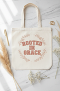 ROOTED IN GRACE cream canvas tote bag flat lay on marble with pampas grass and gold rings